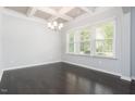 Bright dining room with a modern chandelier, tray ceiling, and large windows for natural light at 3413 S Beaver Ln, Raleigh, NC 27604