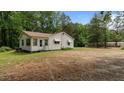 View of the rear exterior with a view of the yard and mature trees offering space and privacy at 3899 Warrenton Rd, Henderson, NC 27537