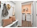 Well-organized mudroom with bench, hooks, and access to the laundry room with washer and dryer at 48 Spirit Springs Rd, Smithfield, NC 27577