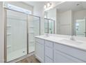 Bathroom features a double vanity with a framed mirror, white cabinets, and a glass-enclosed shower at 504 Winding Creek Dr Dr, Lillington, NC 27546