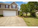 Lovely townhouse featuring a two-car garage, manicured lawn, and healthy landscaping at 524 Woodson Dr, Clayton, NC 27527