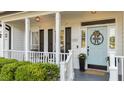 Inviting front porch featuring a light blue door with a welcome mat and beautiful flower pot at 535 W Holding Ave, Wake Forest, NC 27587
