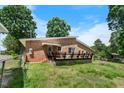 View of the backyard with a wooden deck, partial fence, and grassy lawn at 5652 Laurel Crest Dr, Durham, NC 27712