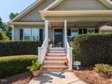 Close-up of the home's entrance with a charming porch, decorative plants, and inviting stairway at 70 King Mackeral Ct, Willow Springs, NC 27592