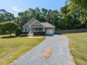 Inviting single-story home with a gravel driveway and well-maintained front yard, showcasing curb appeal at 70 King Mackeral Ct, Willow Springs, NC 27592
