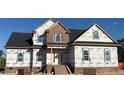 New two-story home construction featuring brick facade, white door and window frames, and a dark roof at 7491 Sweetwater Dr, Nashville, NC 27856