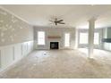 Bright, spacious living room with a fireplace, ceiling fan and wainscoting, ready for personalization at 7491 Sweetwater Dr, Nashville, NC 27856
