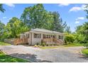 Charming home featuring a gravel driveway, two wooden decks, and light gray brick at 827 Loop Rd Rd, Burlington, NC 27217