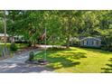 Beautiful blue home with a luscious lawn, a long driveway, mature trees, and an American flag at 8513 Applecross Cir, Apex, NC 27539
