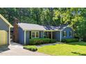 A charming home featuring blue siding, black shutters, a brick chimney, and a well-manicured lawn at 8513 Applecross Cir, Apex, NC 27539