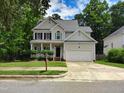 Traditional two-story home with a spacious driveway, attached garage, and a covered front porch at 9009 Miranda Dr, Raleigh, NC 27617