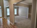 Bright and airy living room with neutral carpet and a large opening to an adjacent room at 9009 Miranda Dr, Raleigh, NC 27617