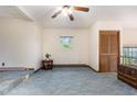 Cozy living room featuring light blue carpet, a ceiling fan, and natural light from the window at 1012 Roxboro St, Haw River, NC 27258
