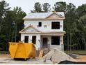 New construction of a two-story home with visible framing and materials, set against a backdrop of lush green trees at 117 Legolas Ct, Middlesex, NC 27557
