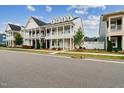 Inviting two-story home featuring double porches, a white facade, and manicured front lawn at 1211 Gloriosa St, Apex, NC 27523