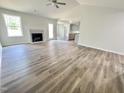 Bright living room featuring wood-look floors, a fireplace, and ample natural light at 138 Sourgum Ct, Zebulon, NC 27597