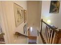 Classic staircase with white railings, wood details, and framed artwork along the walls leading to lower level at 14 Striding Ridge Ct, Durham, NC 27713