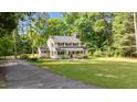 Traditional two-story home with a covered porch, situated on a large lot with a pond at 148 Shadowbrook Dr, Henderson, NC 27537