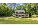 Inviting two-story home with a classic facade, mature trees, and a lush green lawn creating great curb appeal at 148 Shadowbrook Dr, Henderson, NC 27537