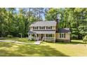 Beautiful home with a covered front porch, classic design and mature trees creating a private, park-like setting at 148 Shadowbrook Dr, Henderson, NC 27537