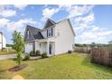 Exterior angle of a two-story home with white siding and a fenced-in backyard and a green lawn at 152 Briar Den Ct, Benson, NC 27504