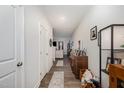 Hallway featuring neutral-colored walls, wood-look flooring, doors, and decor including photo frames at 152 Briar Den Ct, Benson, NC 27504