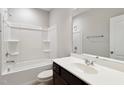 Clean bathroom with a dark vanity, white sink, tub, and a white shower at 1600 Tinos Overlook Way, Apex, NC 27502