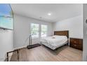 Bright bedroom featuring a queen bed, two windows, and hard surface flooring at 165 Bywood Dr, Roxboro, NC 27573