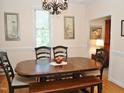 Formal dining room with a wooden table, chairs, and classic chandelier at 1707 Falls Church Rd, Raleigh, NC 27609