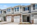 New townhomes featuring stone facades, attached garages, and well-maintained landscaping at 1907 Hinesley Dr, Durham, NC 27703