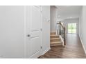 Inviting hallway with hardwood floors, staircase with dark banister, and natural light at 1913 Hinesley Dr, Durham, NC 27703