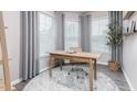 Bright office space has three windows, neutral walls, gray curtains, and a modern wooden desk with chair at 1917 Hinesley Dr, Durham, NC 27703