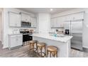 Modern kitchen features gray cabinets, stainless appliances, granite countertops, island with stools and tile backsplash at 1917 Hinesley Dr, Durham, NC 27703