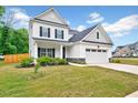 Attractive two-story house with a green lawn, a porch with columns, and a two-car garage at 200 Chateau Way, Angier, NC 27501