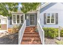 Inviting front porch with brick steps, white railings, and a stylish front door at 2006 Keokuk Ct, Apex, NC 27523
