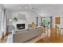 Bright living room with vaulted ceilings, fireplace, and hardwood floors, flowing into dining area at 2006 Keokuk Ct, Apex, NC 27523