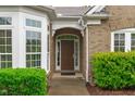 Inviting front entryway featuring a stylish door with sidelights and manicured shrubbery at 208 Beckingham Loop, Cary, NC 27519