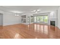 Spacious living room featuring hardwood floors, fireplace, wainscoting and natural light at 208 Beckingham Loop, Cary, NC 27519