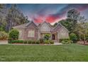Charming two-story home boasting a beautifully landscaped front yard under a dramatic red sky at 216 Colonial Ridge Dr, Pittsboro, NC 27312