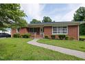 Charming brick home with a manicured lawn, walkway, mature trees and shrubs for great curb appeal at 2315 Oxford Rd, Henderson, NC 27536