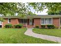 Charming brick home with a manicured lawn, walkway, mature trees and shrubs for great curb appeal at 2315 Oxford Rd, Henderson, NC 27536
