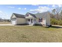 Side view of a cozy house with a two-car garage and a well-maintained lawn at 25 Mannford Ln, Angier, NC 27501