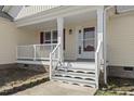 Inviting front porch with white railing and steps leading to the front door and red shutters at 25 Mannford Ln, Angier, NC 27501
