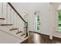 Bright foyer with dark hardwood floors, staircase, and glass door offering a welcoming entrance at 2709 Penfold Ln, Wake Forest, NC 27587