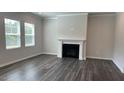 Cozy living room featuring a modern fireplace, hardwood floors and large windows at 3112 Star Gazing Ln, Durham, NC 27703