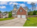 Two-story home with brick and siding facade, a two-car garage, and an extended driveway at 32 Lattimore Rd, Cameron, NC 28326