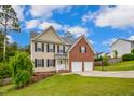 Two-story home showcasing a combination of brick and siding, complemented by a green lawn at 32 Lattimore Rd, Cameron, NC 28326
