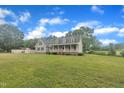 A charming home with lush greenery, a large yard, and inviting curb appeal at 397 Meadow Rd, Kenly, NC 27542