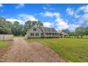 Well-maintained home featuring ample yard space, a gravel driveway, and lush trees at 397 Meadow Rd, Kenly, NC 27542