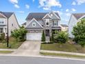 Two-story home with stone accents, attached garage, small front porch and well-manicured landscaping at 5104 Windmere Chase Dr, Raleigh, NC 27616